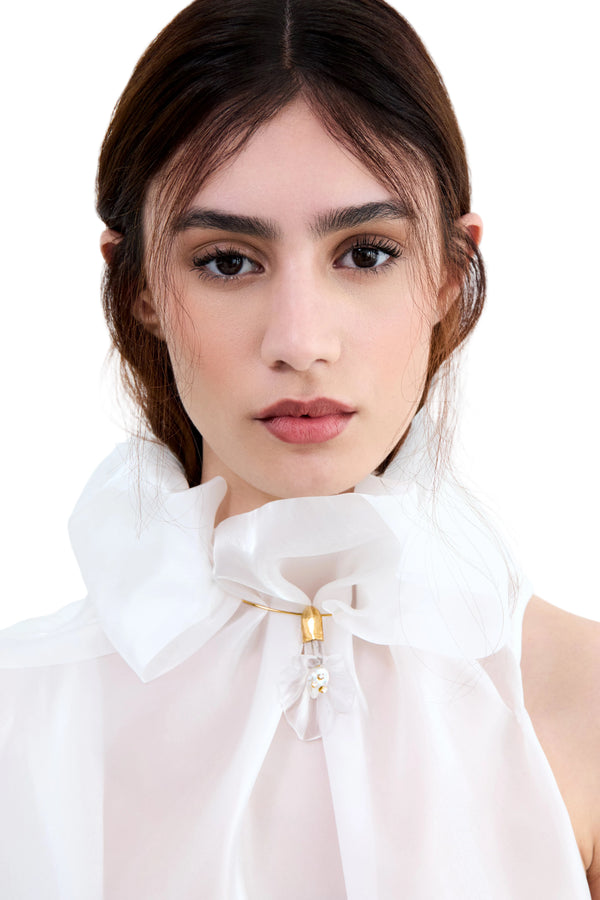 Woman wearing a white blouse with a high collar on a white background